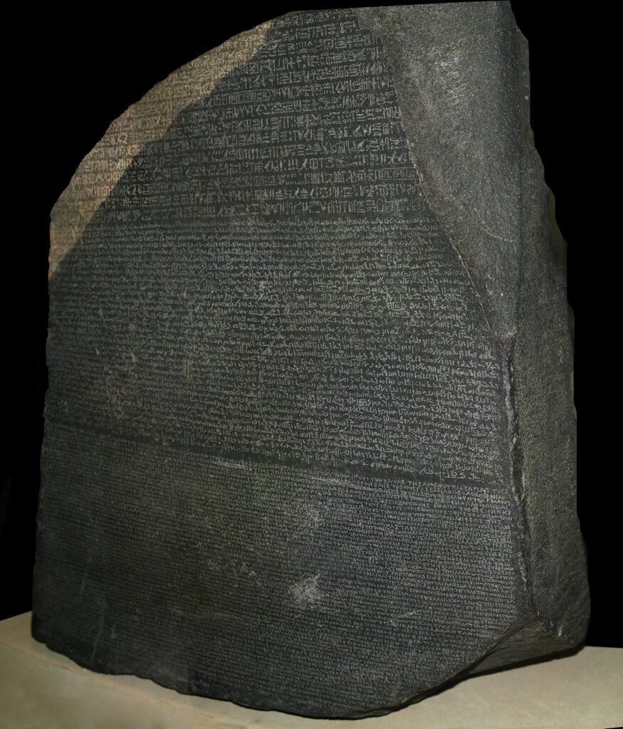 A large gray stone features many lines of small text etched into its flat front surface.