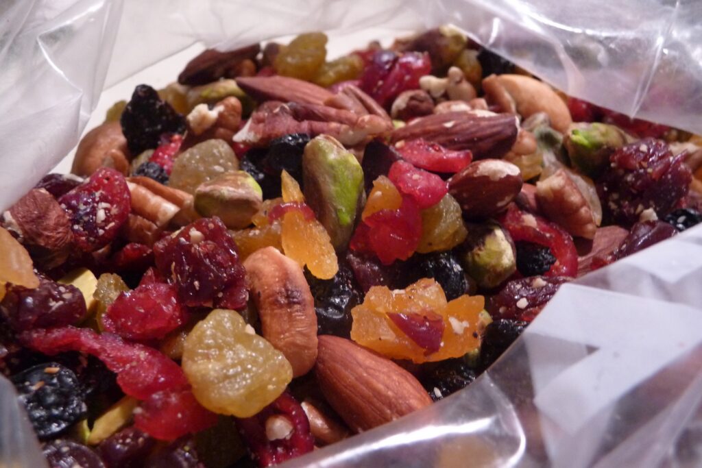 A close-up features a pile of nuts and dried fruits in an open plastic bag.