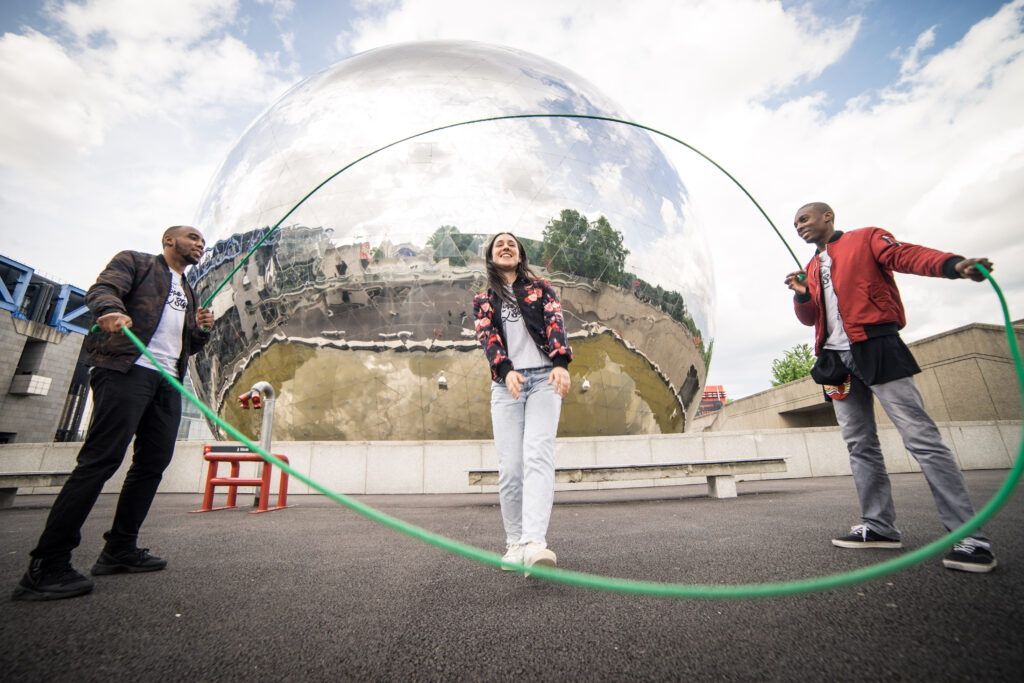 A photograph features three people, two turning alternate ends of two jump ropes double-Dutch style (swinging them at opposite times), and one preparing to jump in.