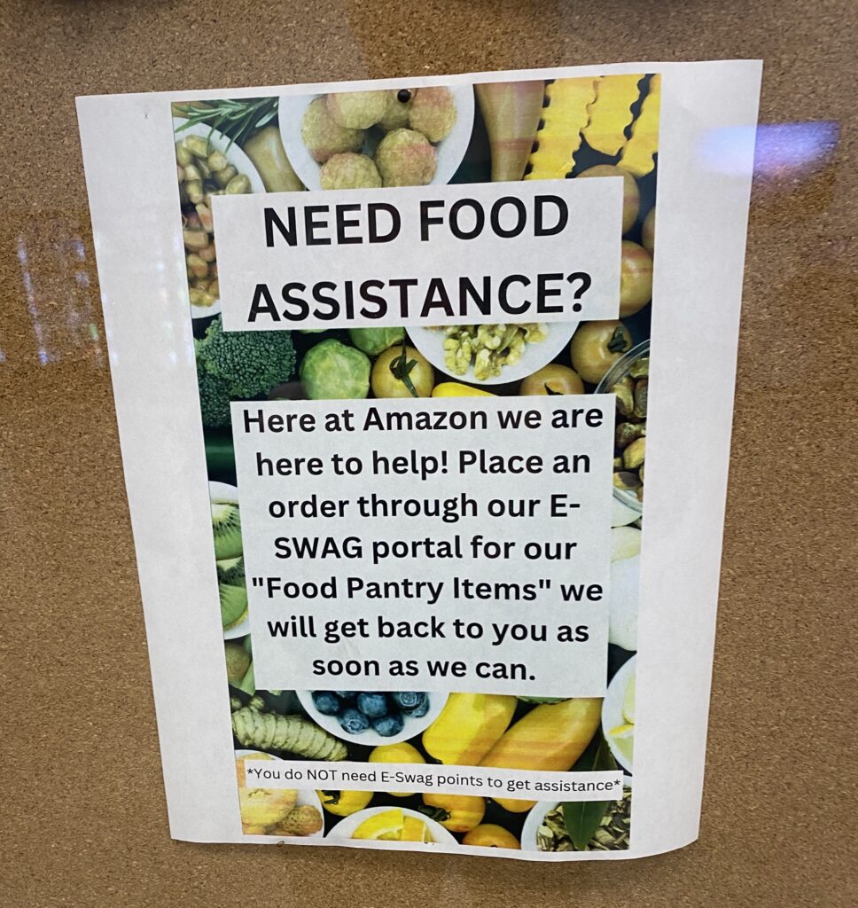 A printed flyer has vegetables in the background with the following text on a white box in the foreground: “Need Food Assistance? Here at Amazon we are here to help! Place an order through our E-SWAG portal for our ‘Food Pantry Items’ we will get back to you as soon as we can. You do not need E-Swag points to get assistance.”