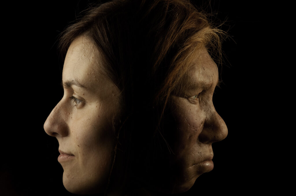 Against a black background, two faces in profile look in opposite directions. The one on the left has straight brown hair with pale skin, and the one on the right has slightly darker skin and disheveled orange hair.