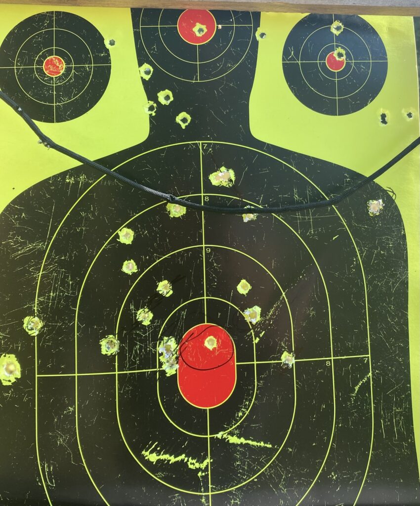 Against a yellow background, a black silhouette of a person is marked with four targets near to and on the head and chest areas, with red sections to designate bull’s-eyes.
