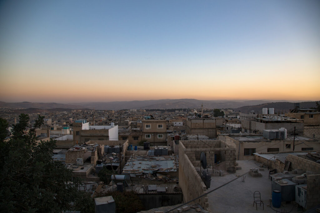 An aerial view shows a large area densely filled with concrete buildings.