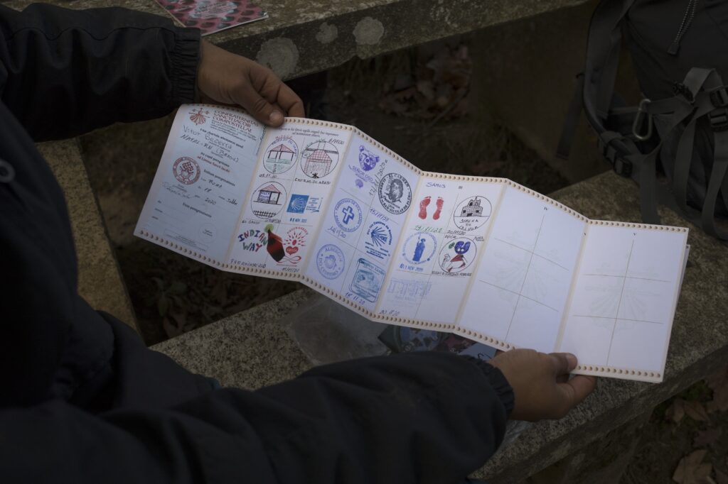 Two hands hold a long piece of white paper with colorful graphics and words written across it.