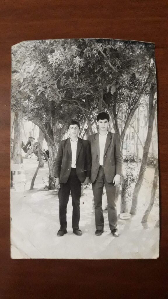 A black-and-white photograph depicts a missing person and his brother in front of a copse.