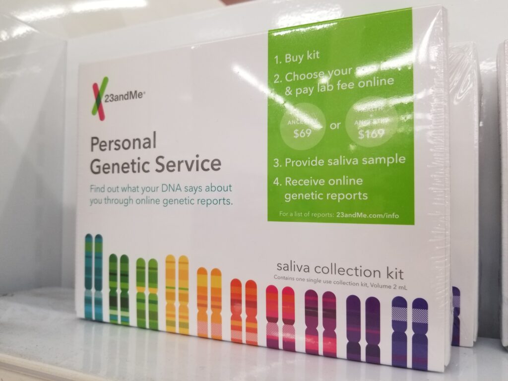 A white box with the words “Personal Genetic Service” and colorful graphic representations of genes sits on a shelf.