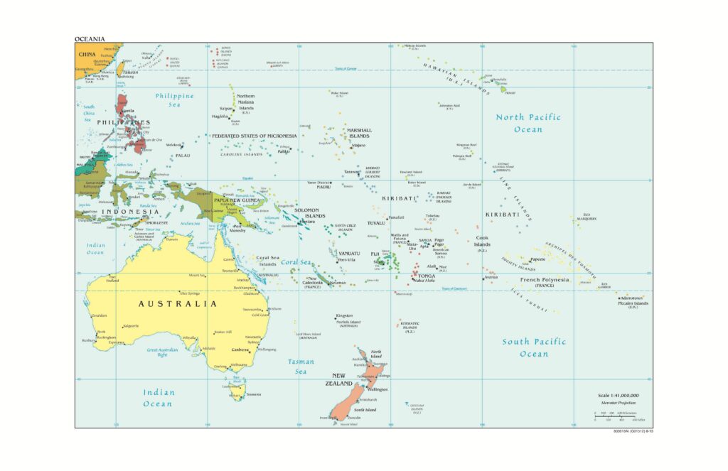 A map depicts a blue ocean crisscrossed by latitude and longitude lines. Landmasses and chains of islands are shaded in various colors, including pale yellow, olive, coral, and orange. Micronesia, as depicted in this map of Oceania, is a region that includes Palau, the Federated States of Micronesia, Marshall Islands, Nauru, and Kiribati, and the U.S. territories Guam and Northern Mariana Islands.