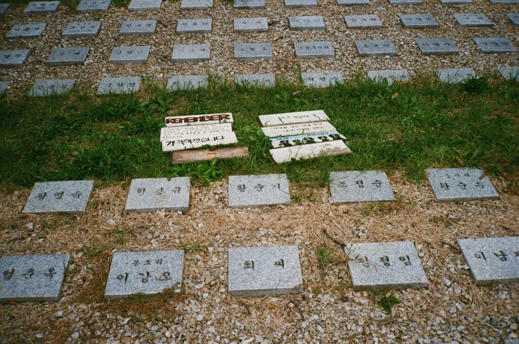 Granite plaques are laid in rows on the ground, with some signs in the Korean language laid nearby.