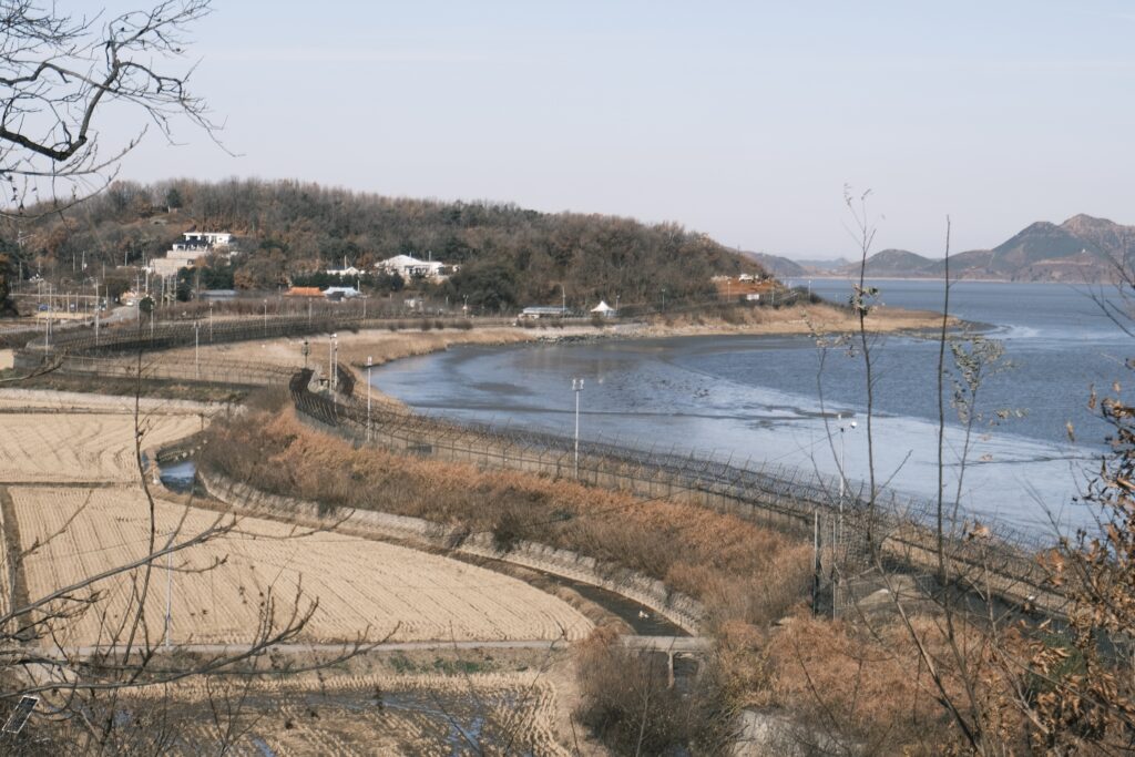 Military-style fencing runs along a coast.